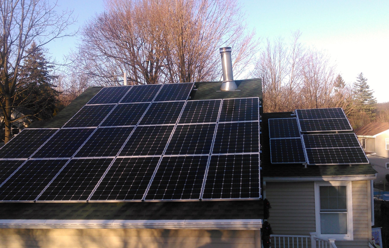 American Solar Partners - Slanted solar panel installation on the back of a slanted residential roof surrounding a vent