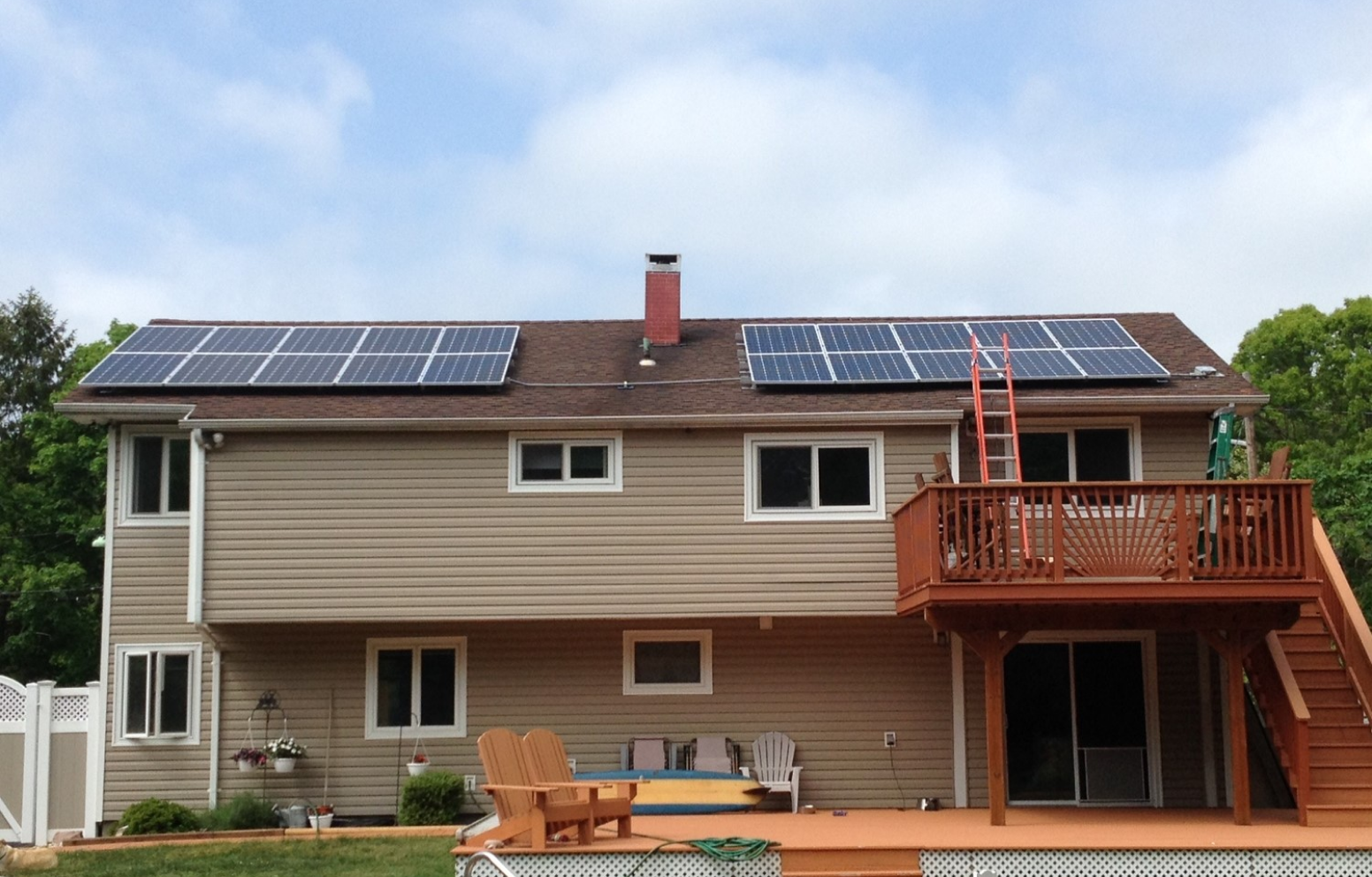 American Solar Partners - Slanted solar panel installation on the front of a slanted residential roof surrounding a chimney