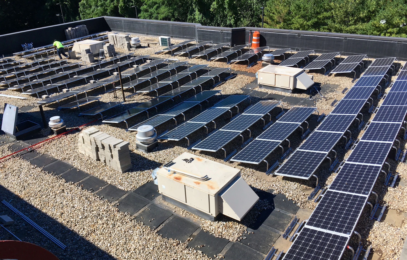 American Solar Partners - Commercial solar panel installation on a flat roof covered with sand, rocks and pebbles