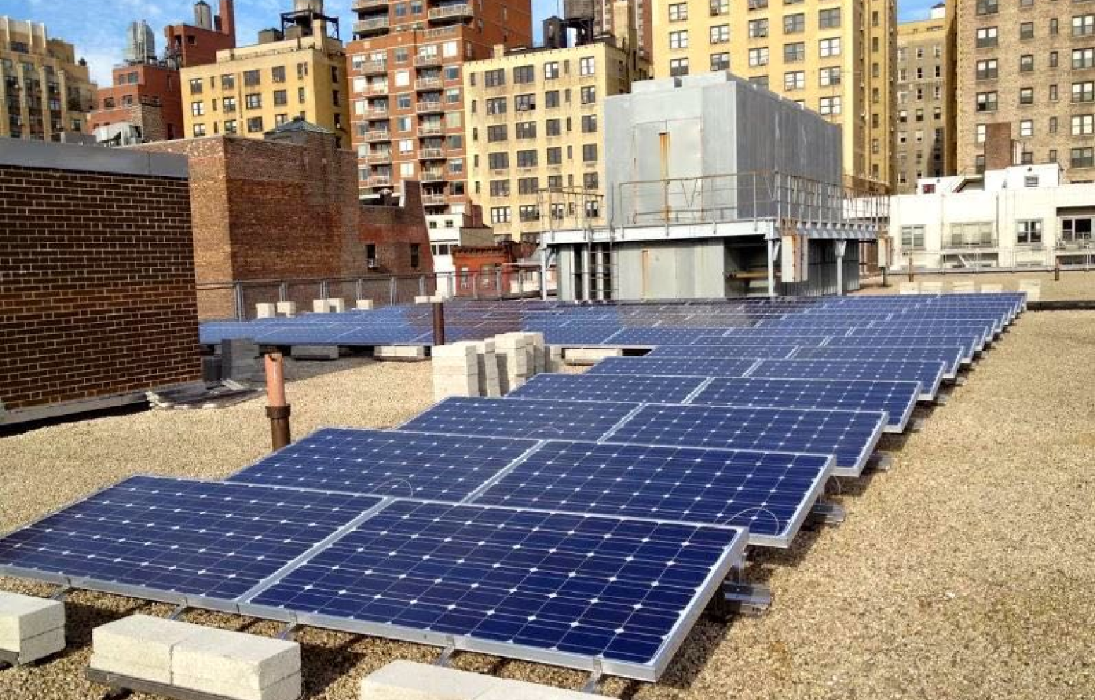 American Solar Partners - Commercial solar panel installation on a flat roof covered with sand, rocks and pebbles