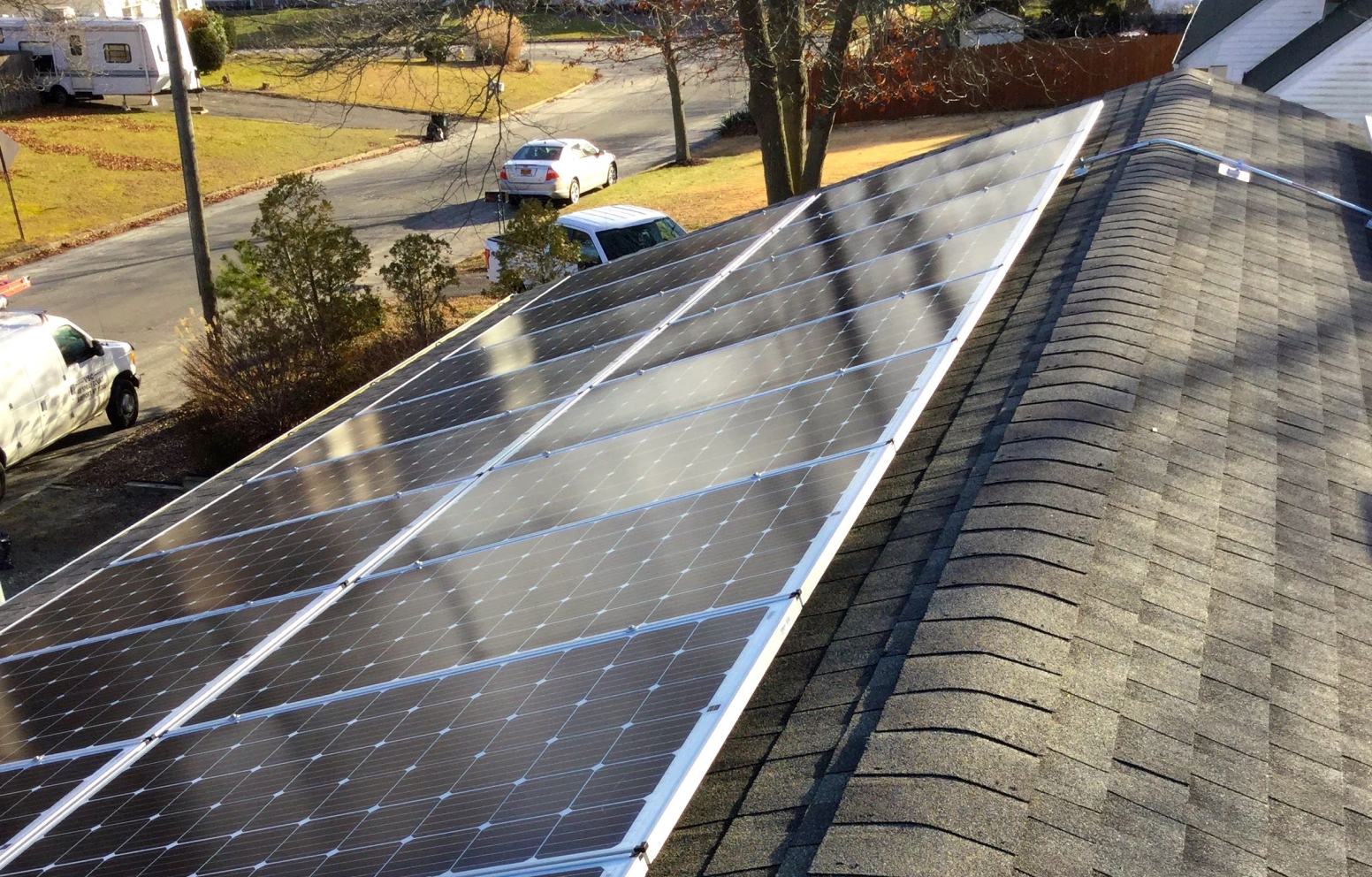 American Solar Partners - Angled solar panel installation on a slanted residential roof in a surburban area