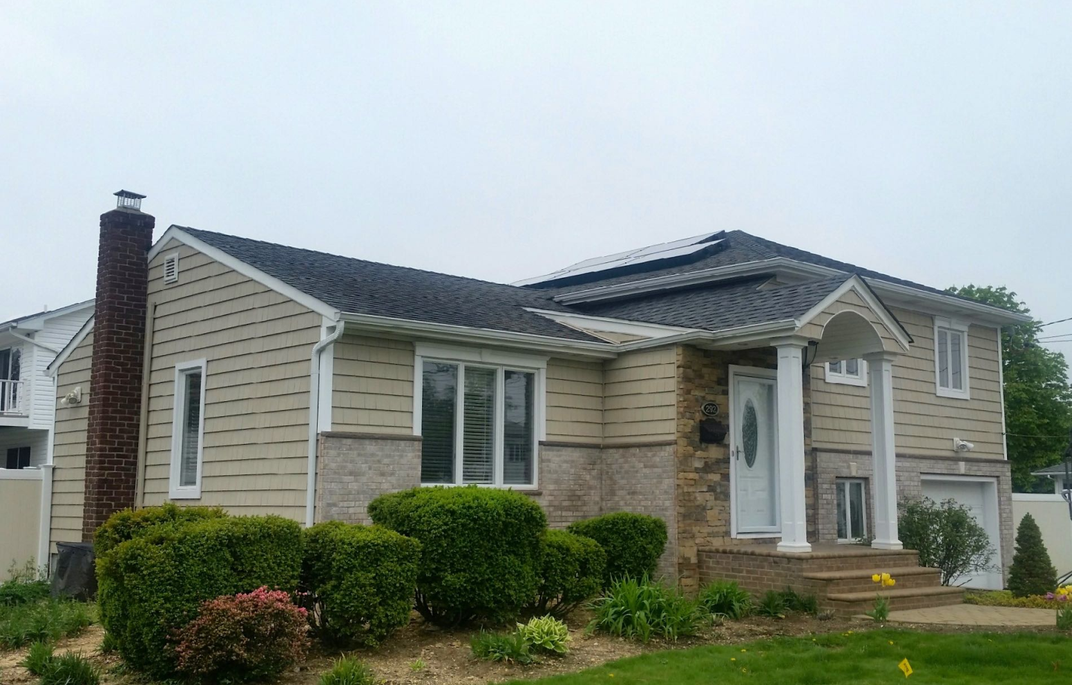 American Solar Partners - Angled solar panel installation on a slanted residential roof in a surburban area