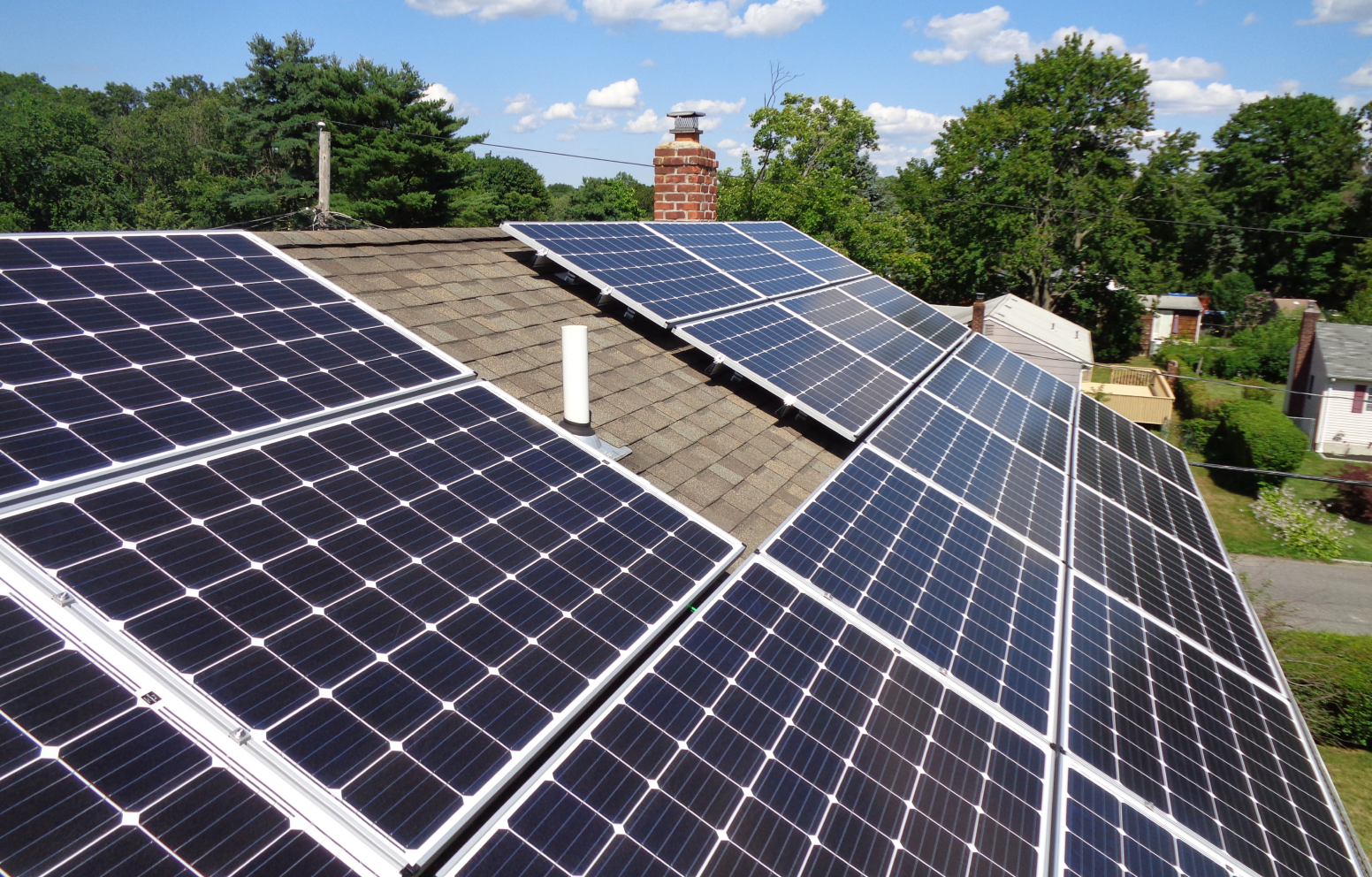 American Solar Partners - Angled solar panel installation on a slanted residential roof surrounding a vent