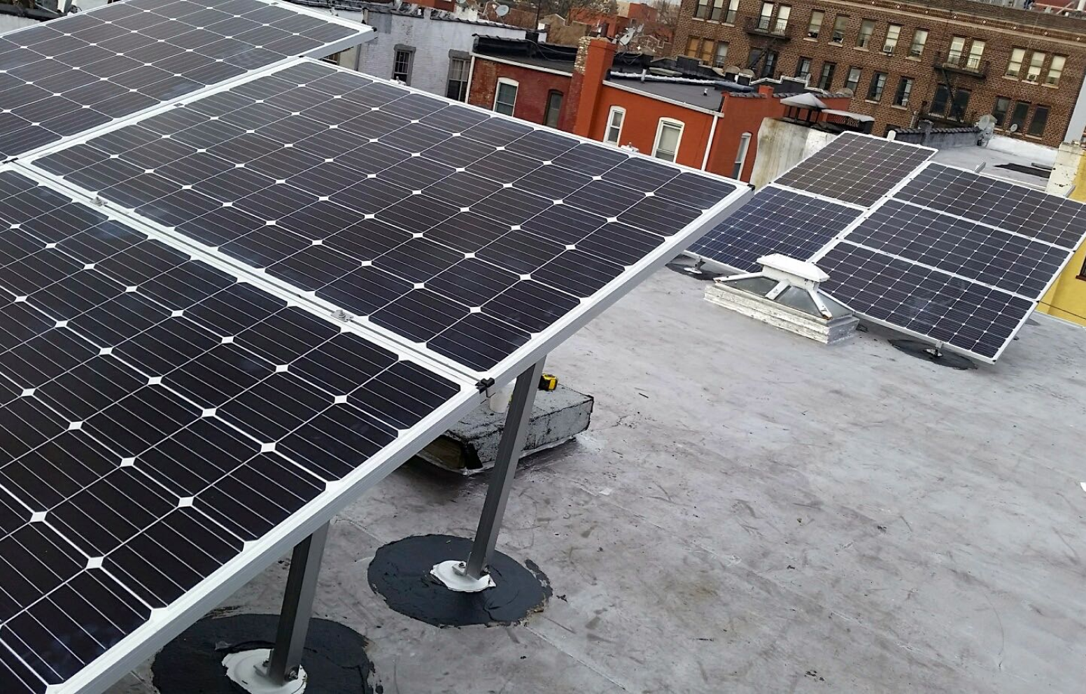 American Solar Partners - Angled solar panel installation on a flat residential roof in an urban area